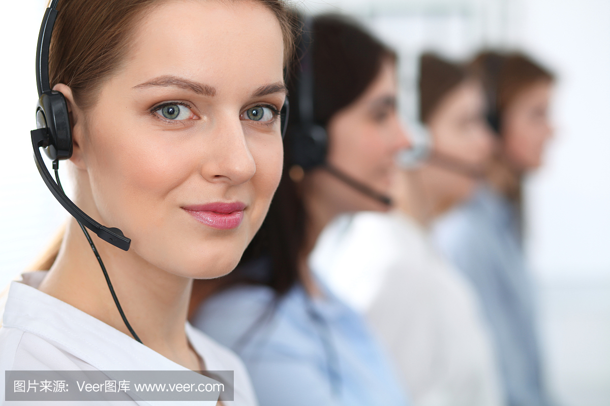 呼叫中心。美丽开朗微笑的操作员戴着耳机咨询客户。客户服务的经营理念